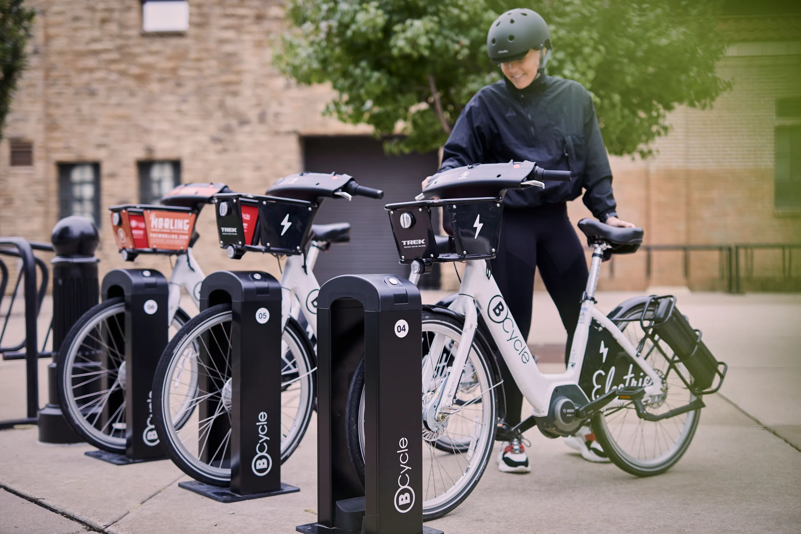 woman pulling a bike share bicycle out of the dock
