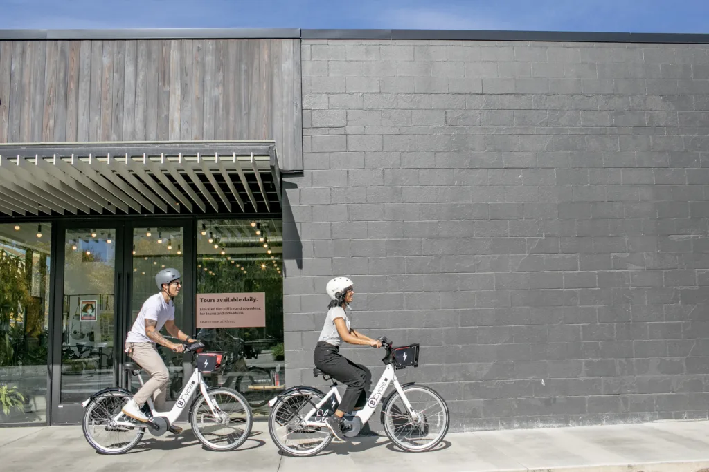 couple riding bike share bicycle