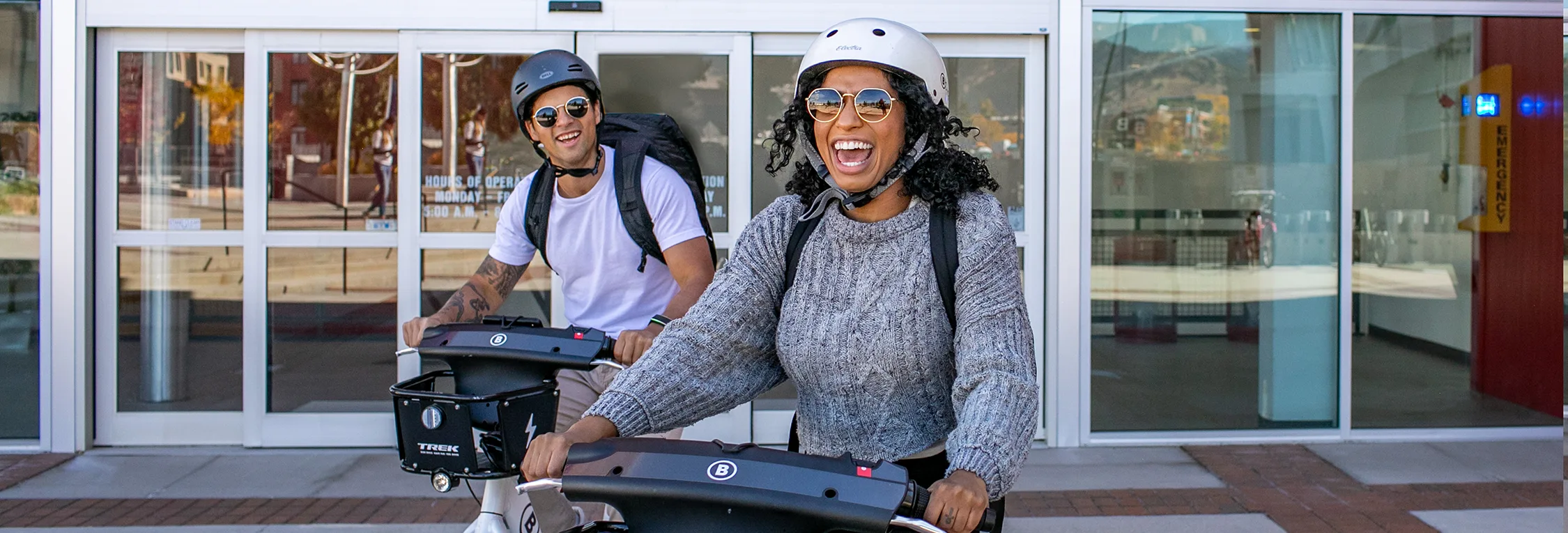 man and woman laughing hard while riding bike share bicycles