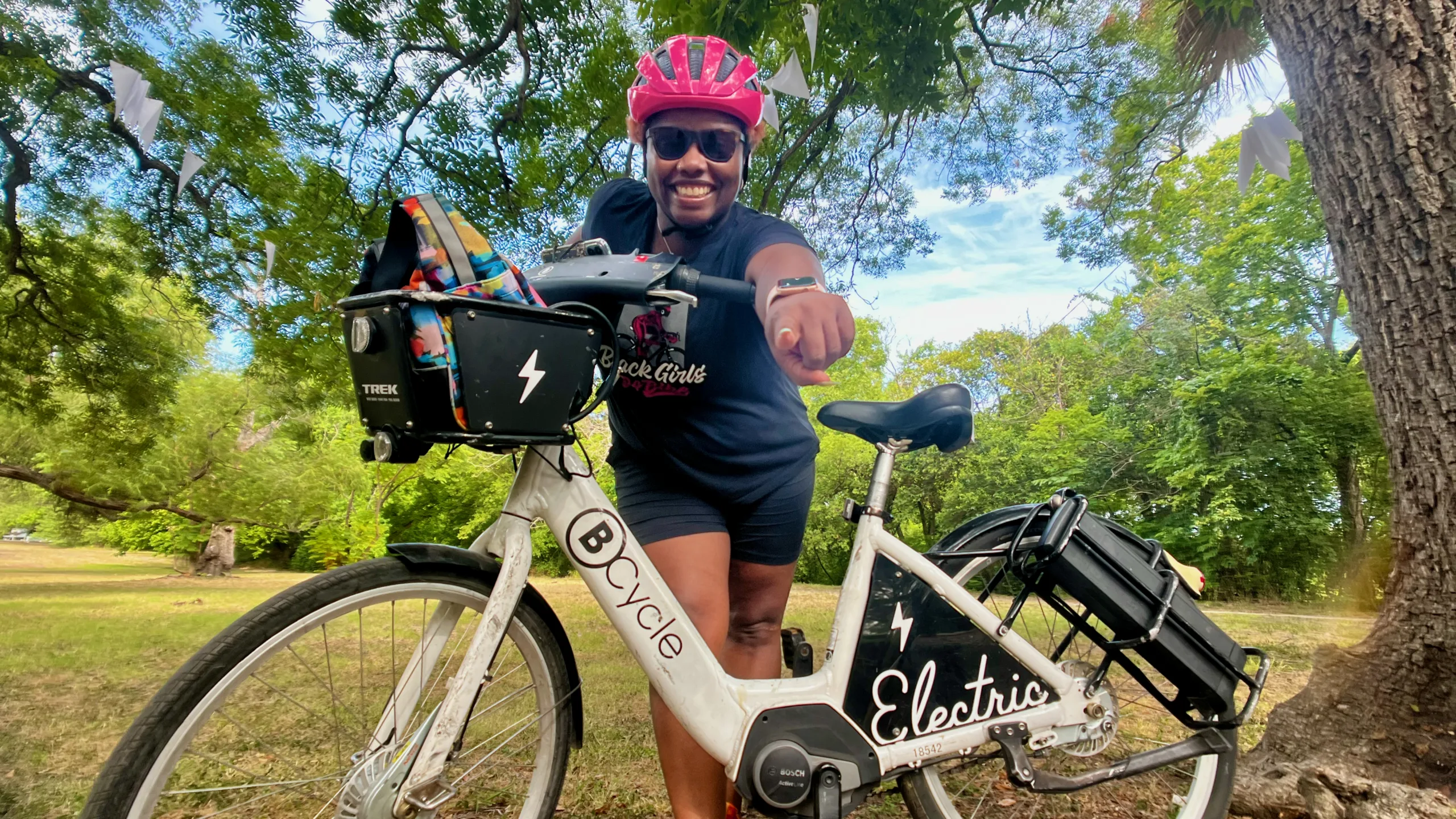 photo of woman leaning over a bike share bicycle pointing at the camera